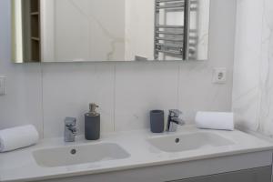 波尔蒂芒Luxury Villa Aleana的白色的浴室设有两个盥洗盆和镜子