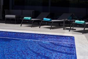 波尔蒂芒Luxury Villa Aleana的一个带2张桌子和2把椅子的游泳池