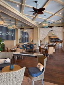 德斯坦Henderson Beach Resort的一间带桌椅和天花板的餐厅