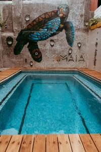 萨尤利塔Amaia Boutique Hotel的墙上有乌龟的游泳池