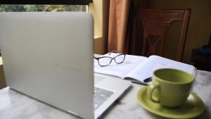 利马艾法罗力托酒店的坐在桌子上的笔记本电脑,喝杯咖啡