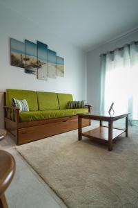 阿雷亚布兰卡海滩White Beach House的客厅配有绿色沙发和茶几