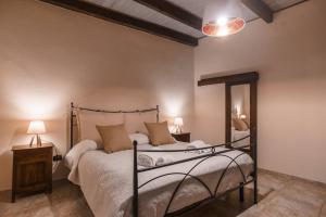 阿尔盖罗Miguel House的一间卧室配有一张床、两张桌子和两盏灯。