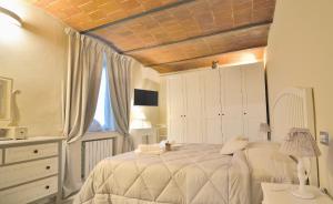 皮斯托亚Borgo in Città的卧室设有一张白色大床和一扇窗户。