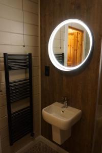 基林Cosy Rowan woodland lodge no1的一间带水槽和镜子的浴室