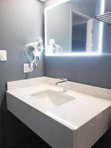 萨德伯里Moonlight Inn and Suites Sudbury的浴室设有白色水槽和镜子