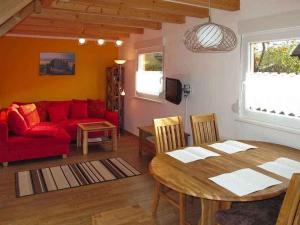 奥斯特西巴德钦诺维茨Holiday home in Zinnowitz (Seebad) 33031的客厅配有桌子和红色沙发