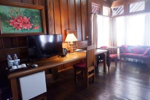 万慈Wakatobi Patuno Diving and Beach Resort by SAHID的一间带书桌和电视的房间和一间客厅