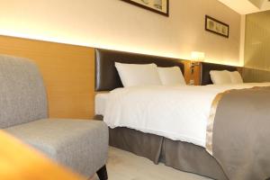 嘉义市尊皇大饭店 的酒店客房,配有两张床和椅子