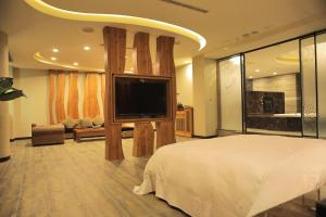 新营欧悦连锁精品汽车旅馆新营馆的一间卧室配有一张大床和一台平面电视