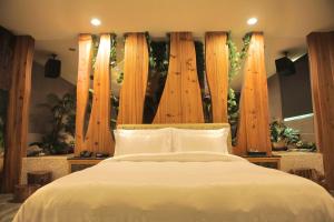 新营欧悦连锁精品汽车旅馆新营馆的卧室配有白色的木柱床
