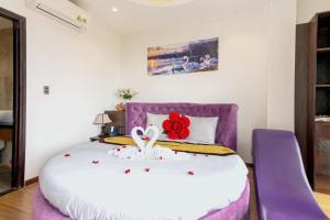 会安晃特林酒店的一间卧室配有一张紫色床,上面有红花