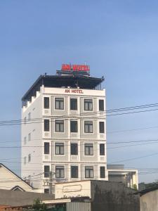 潘切An Hotel Phan Thiết的白色的建筑,上面有标志