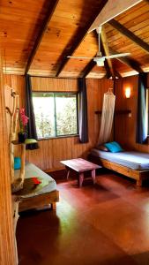PaopaoEco Lodge Village Temanoha的小屋内带两张床和一张桌子的房间