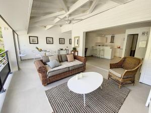 Anse Marcel Acacia Marina, luxurious Duplex, walkable beach的客厅配有沙发、两把椅子和一张桌子