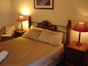 Stockwell特鲁罗地磅汽车旅馆 的一间卧室配有一张床、两盏灯和一把椅子