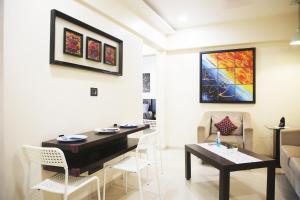 孟买Lite Stays - Vile Parle East的客厅配有桌椅和沙发