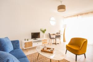阿维尼翁新城Zenao Appart'hôtels Villeneuve-lès-Avignon的客厅配有蓝色的沙发和椅子