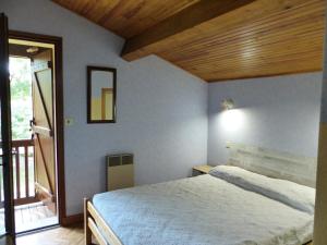 奥瑟戈尔Villa Paloma Pour 8 Personnes的一间卧室设有一张床和木制天花板