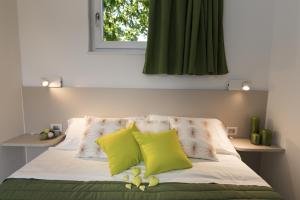 拉齐塞Piani di Clodia Holidaypark的一张带两个黄色枕头的床和窗户