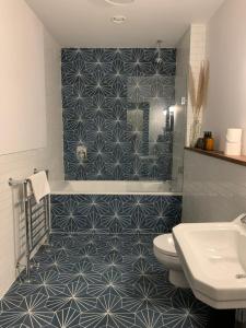爱丁堡Royal Bolthole的浴室设有蓝色和白色瓷砖淋浴。