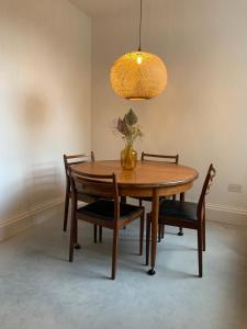 爱丁堡Royal Bolthole的餐桌和椅子,上面有花瓶