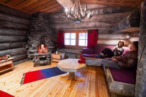 萨利色尔卡卡克斯劳塔宁阿克蒂克度假酒店 - 圆顶小屋和小木屋的小木屋内两人坐在沙发上