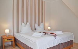 KerkwitzFerienwohnung Wiesenblick的一间卧室配有带白色床单和枕头的床。