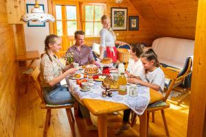 拉什科皮尔克农场住宿酒店的家庭在小屋的餐桌上吃晚餐