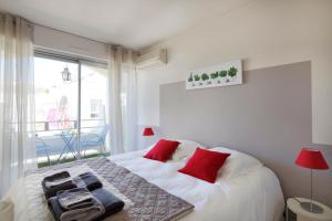 阿维尼翁Appartement Moustier - Welkeys的一间卧室配有一张带红色枕头的床
