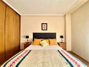 莱昂Housingleón - San Marcos con garaje的一间卧室设有一张大床和两个床头柜
