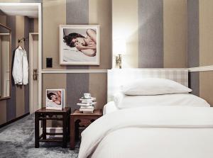 苏黎世金德里酒店的一间卧室配有一张床和一张带照片的边桌