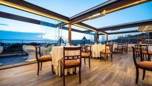 比萨杜尔墨大酒店的一间设有桌椅的餐厅,享有美景。