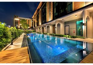 罗勇PLAAI Plus Hotel Rayong的一座建筑物中央的游泳池