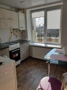 索罗卡Apartament in chirie Moldova or.Soroca的厨房配有炉灶、桌子和窗户。