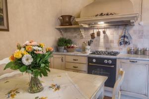 圣吉米纳诺Tenuta Guardastelle - Agriturismo and vineyard的厨房配有一张桌子,上面放着花瓶