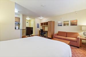 纽波特纽斯Extended Stay America Suites - Newport News - Yorktown的酒店客房配有一张床、一张沙发和一张书桌。