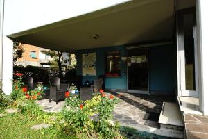 帕尔马帕米贾尼诺公寓的房屋设有一座带椅子和鲜花的庭院