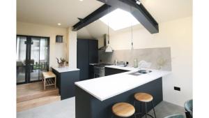 牛津Pass the Keys Stunning, Brand New 3BR Home - Central Oxford的厨房配有水槽和带凳子的台面