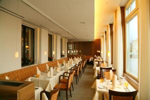 Oranienbaum-Wörlitz祖姆斯汀环形酒店的一间设有白色桌椅的用餐室