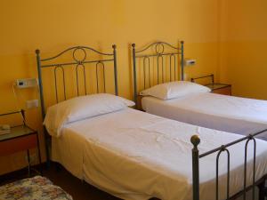 苏尔扎诺Albergo Ristorante Aquila的黄色墙壁客房的两张床