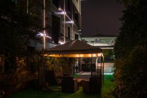 奥里奥阿塞里奥奥瑞奥57号公寓酒店的一座带遮阳伞的庭院,在晚上在大楼前