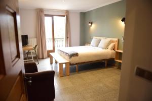 加利扎诺Hotel Vijanera的一间卧室配有一张床、一张桌子和一个窗户。