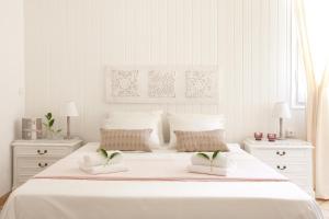 巴塞罗那穆塔纳尔酒店的白色卧室,配有一张带2晚台架的大型白色床