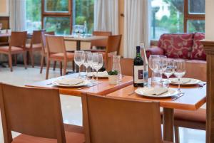 桑迪卡Hospedium Hotel Blu Sondika的一张桌子,上面放着眼镜和一瓶葡萄酒