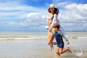 塞古罗港Hotel Brisa da Praia的一名在海滩上玩耍的女人和一名儿童
