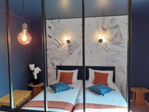 蒙吕松CHARMES EN VILLE Le Charme Poétique的一间卧室设有玻璃墙、一张床和两个枕头