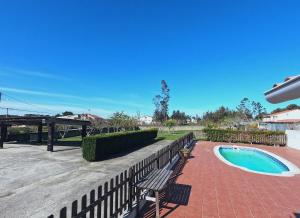 桑亨霍A Casa do Lareiro的一个带长凳和游泳池的庭院