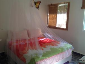 苏莎亚大自然村度假屋的一间卧室配有一张带蚊帐的床