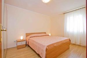诺维格勒伊斯特拉Two-Bedroom Apartment in Novigrad I的一间卧室配有一张床和一个带窗户的床头柜